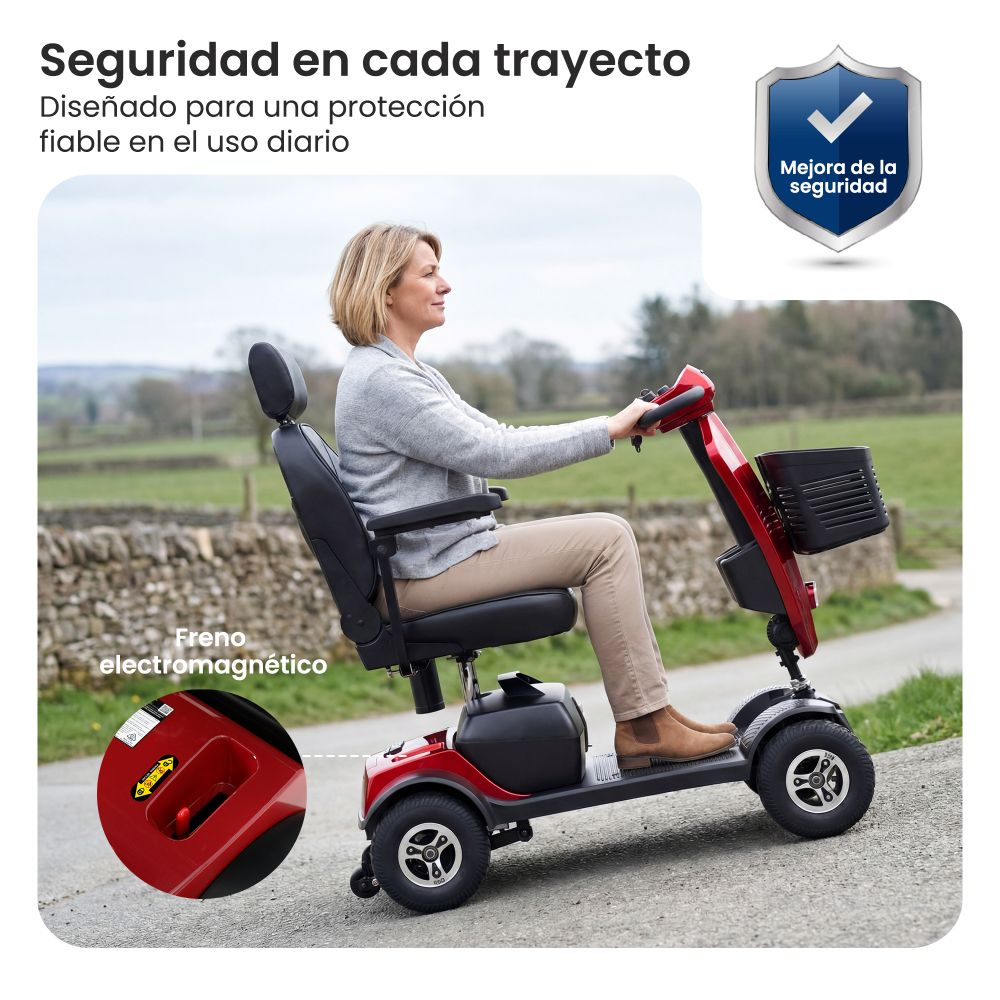 Una mujer conduce un scooter de movilidad rojo al aire libre. Primer plano muestra el freno.