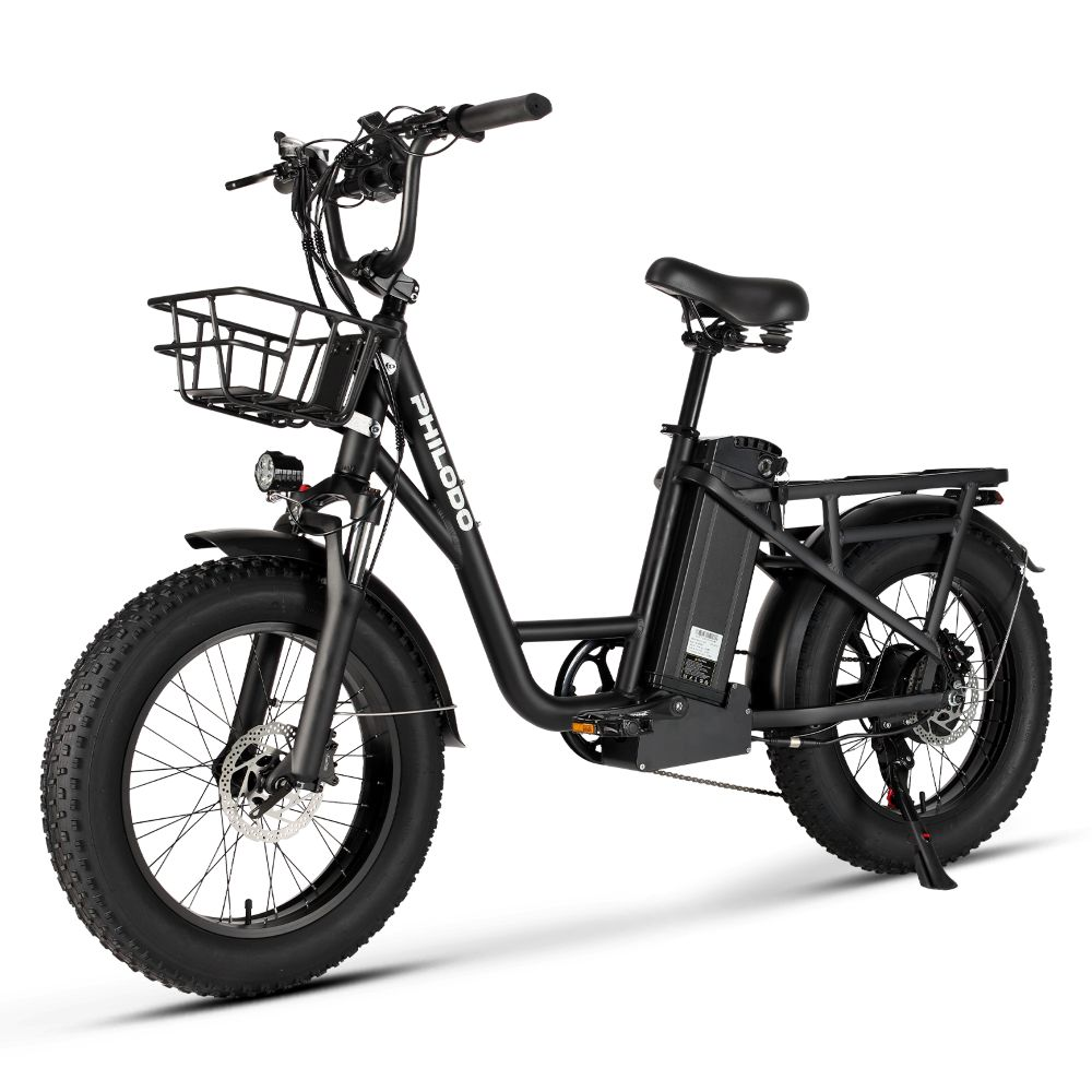 Una bicicleta eléctrica negra de llantas anchas con cesta, batería y portaequipajes.