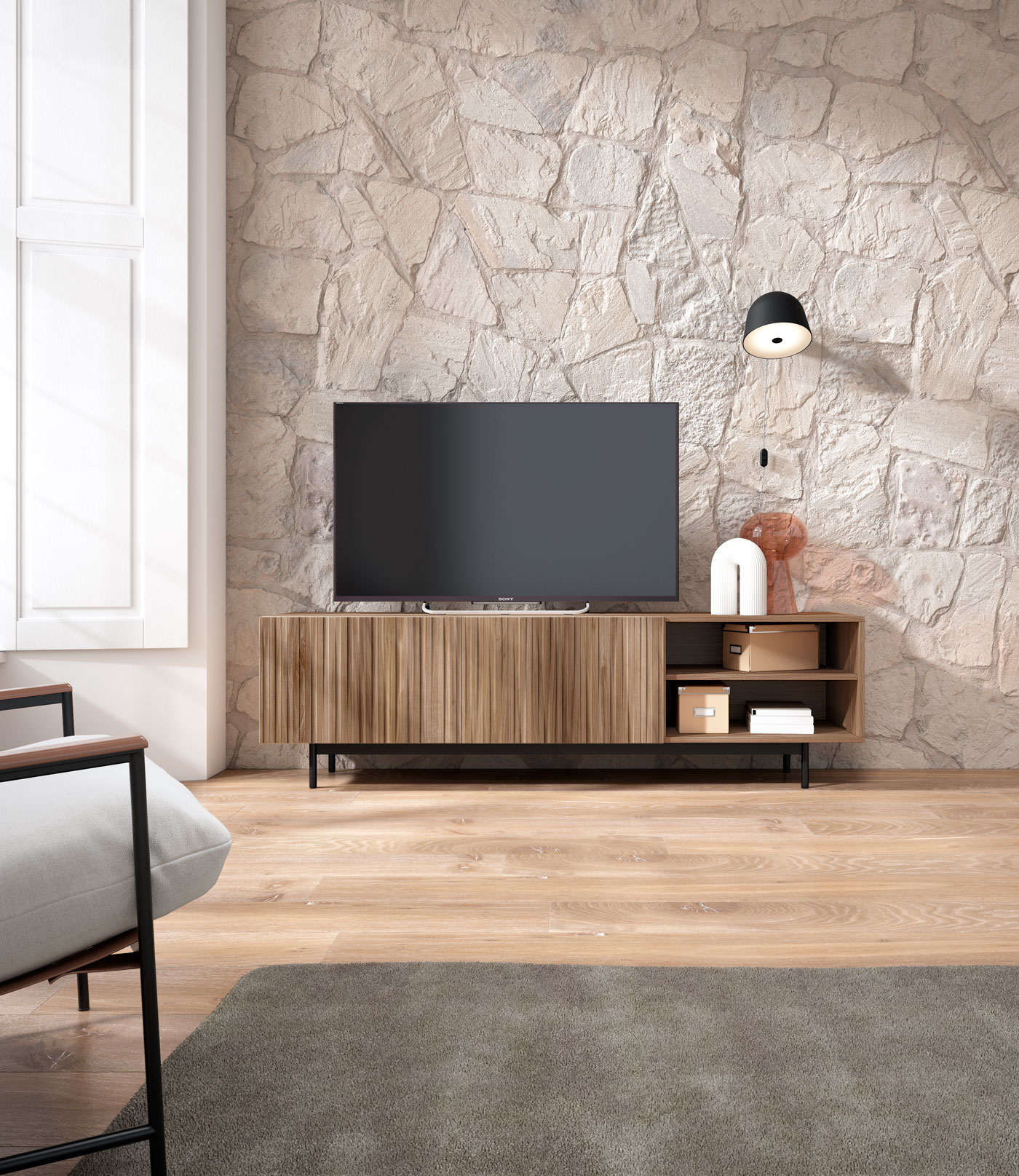 Sala de estar con pared de piedra, mueble de TV, sillón y alfombra.