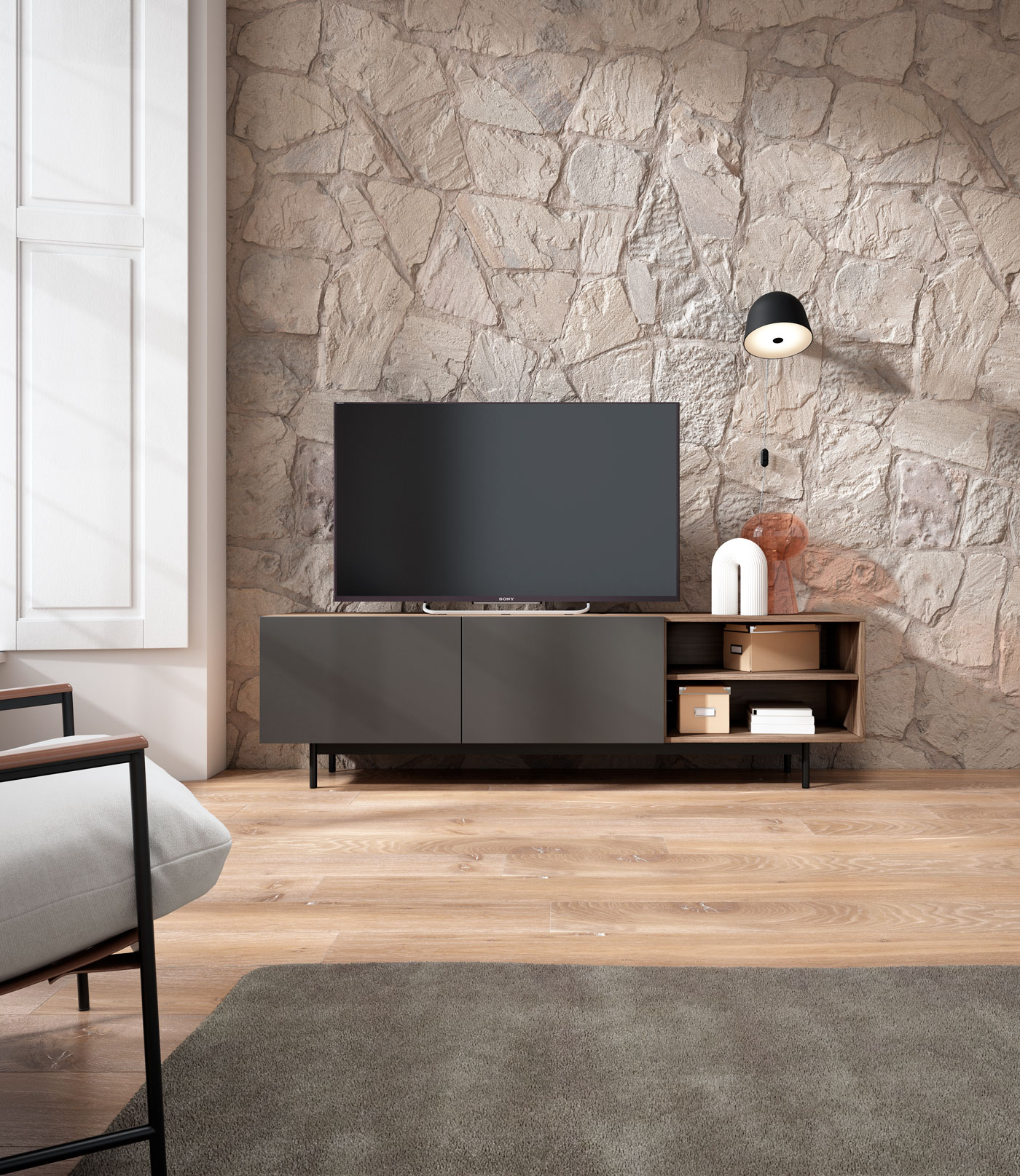 Moderno salón con TV, aparador y sillón frente a pared de piedra.