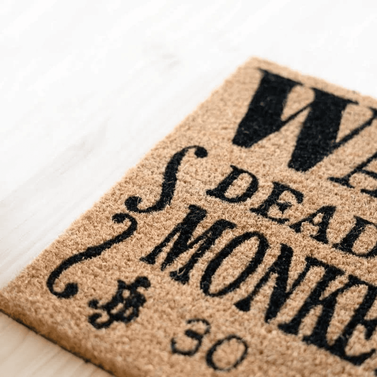 Felpudo de coco con letras negras: "No nos metemos con monos muertos $30".