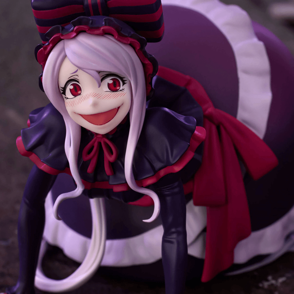 Figura de anime con vestido negro, acentos rojos y volantes blancos.