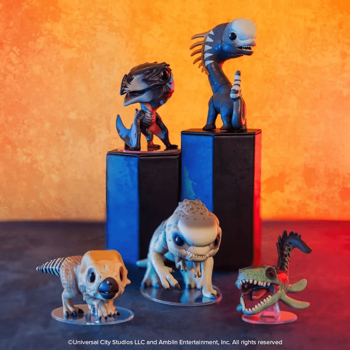 Cuatro figuras de dinosaurios sobre pedestales ante fondo texturizado naranja.