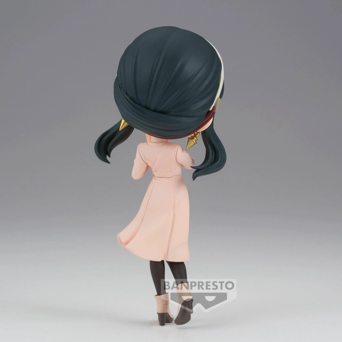 Una figura de cabello oscuro con abrigo rosa y medias oscuras.