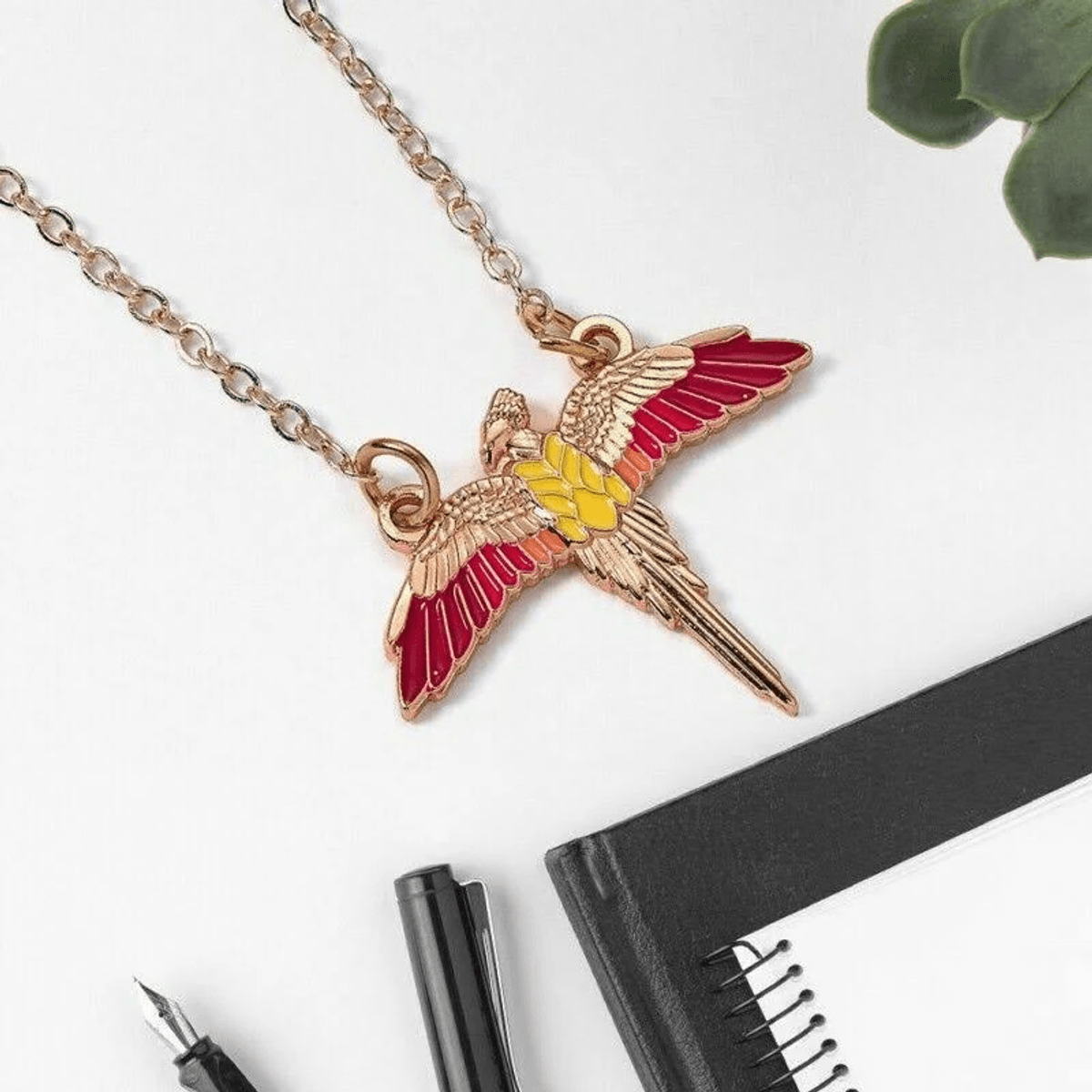 Un collar con un colgante de loro colorido yace sobre un fondo blanco.