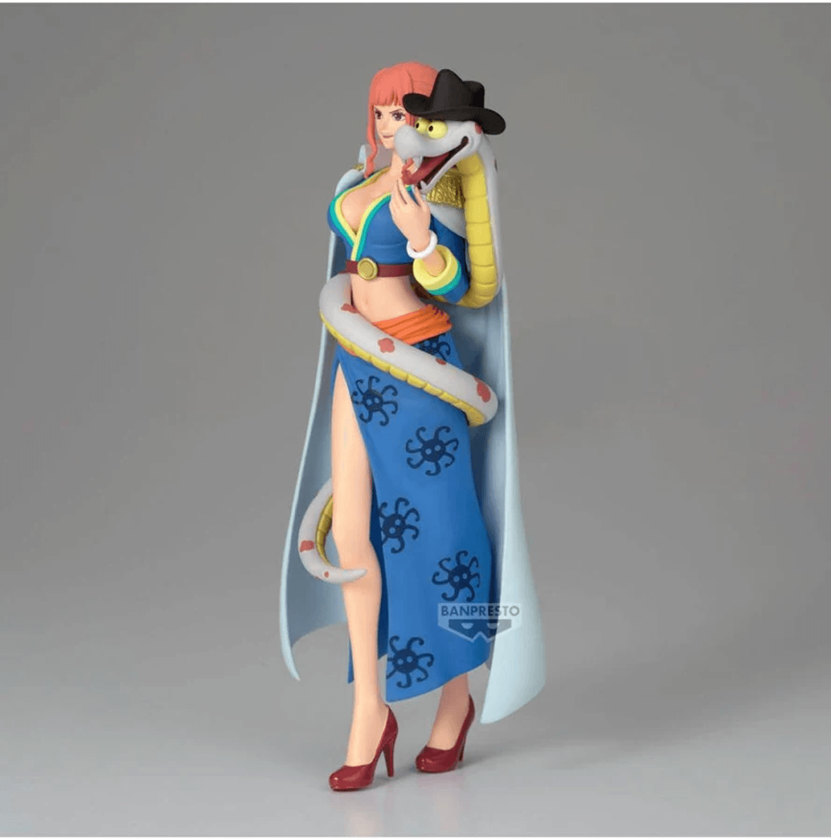 Una figura de mujer con pelo rosa con vestido azul estampado de serpientes. Una serpiente lleva sombrero.