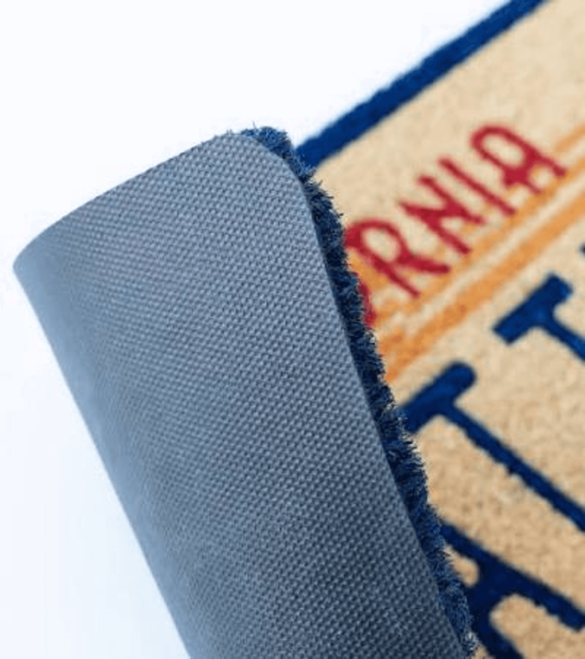 El reverso de un felpudo con borde azul y texto.