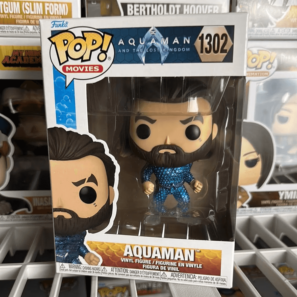 Figura de vinilo Funko Pop! Aquaman 1302 en caja, con otras figuras detrás.