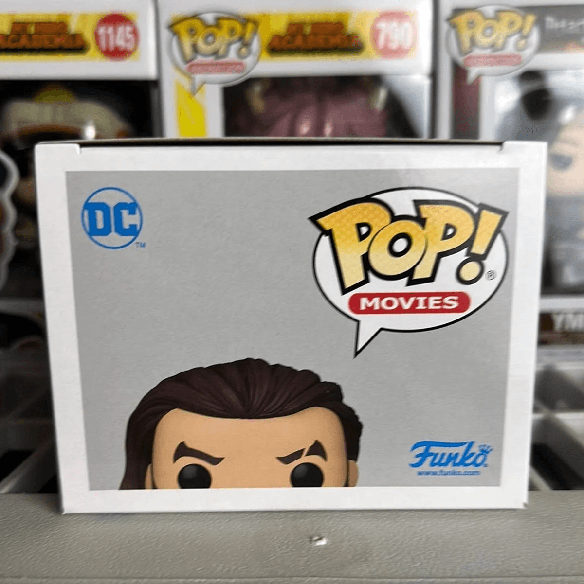 Caja Funko Pop de DC Comics mostrando ojos y cabello de personaje.