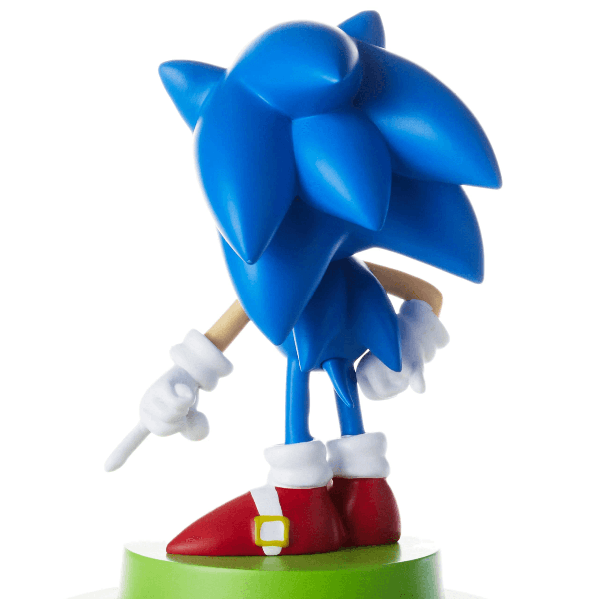 Figura azul de Sonic con zapatos rojos y guantes blancos, sobre una base verde.