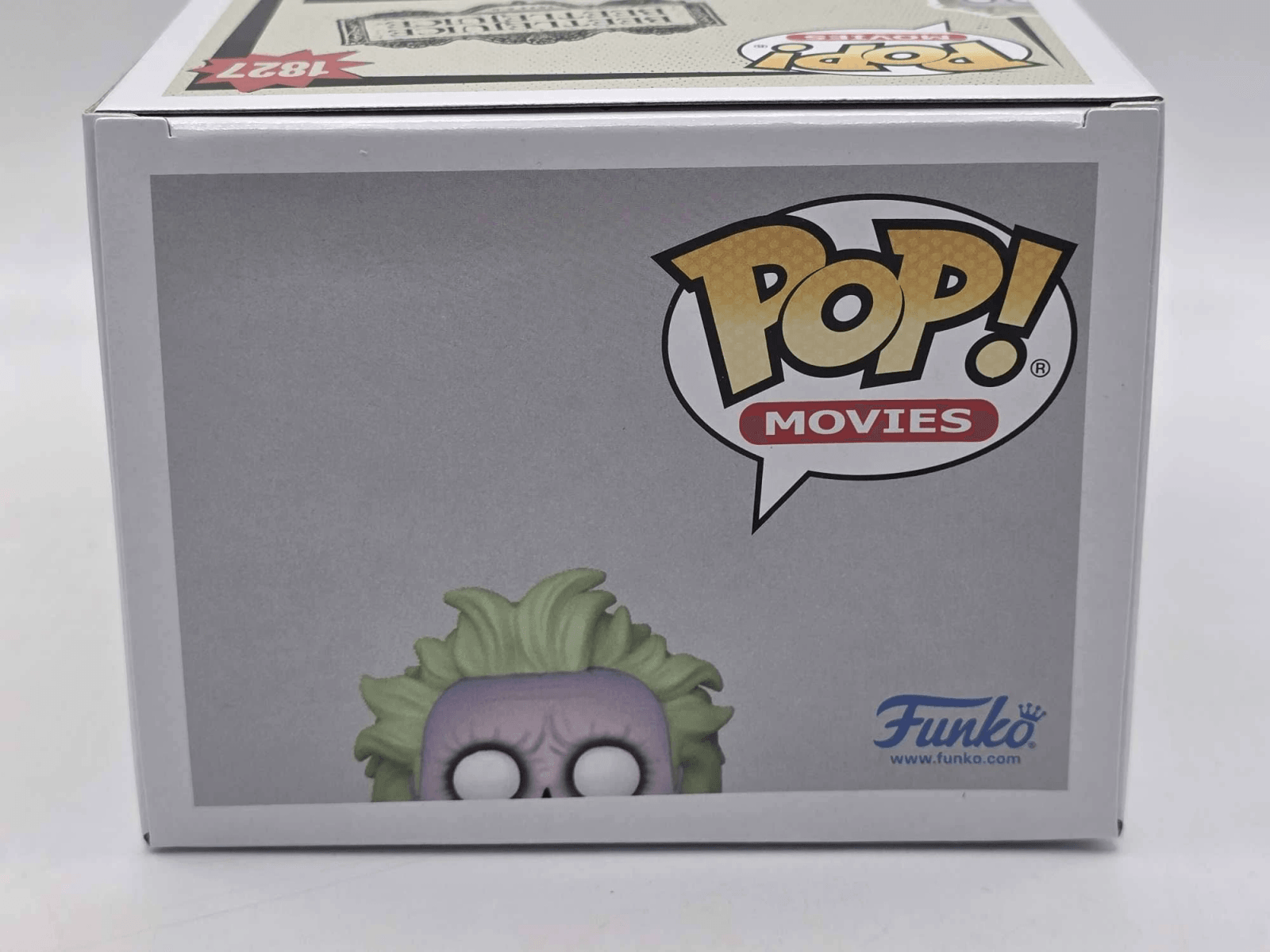Una caja Funko Pop! con Beetlejuice asomándose por el borde inferior.