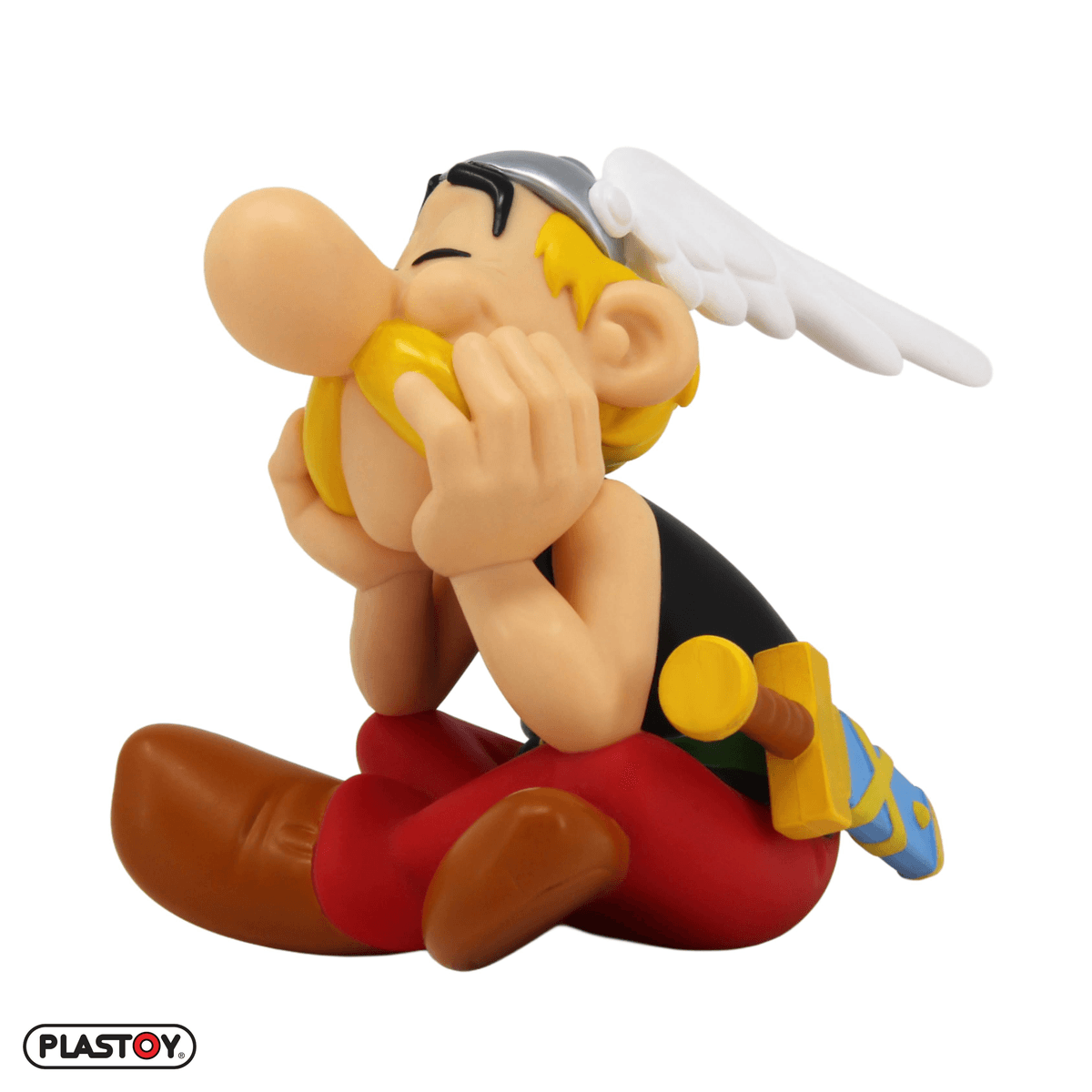 Una figura de Astérix sentado con los ojos cerrados, las manos cerca de la boca.