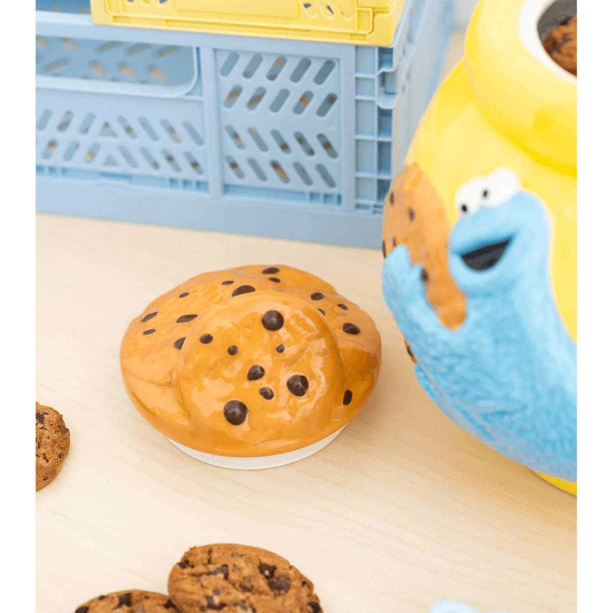 Tarro de galletas de Monstruo Comegalletas con galletas de chispas de chocolate y caja azul.