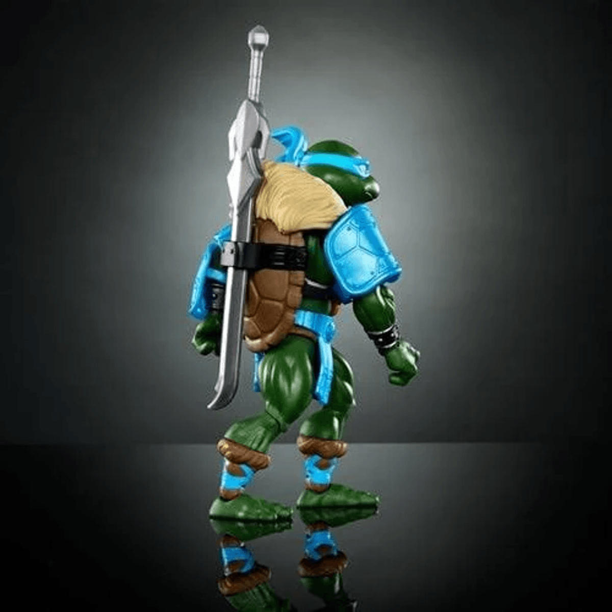 Figura de acción de tortuga ninja verde con armadura azul, lleva una espada en la espalda.