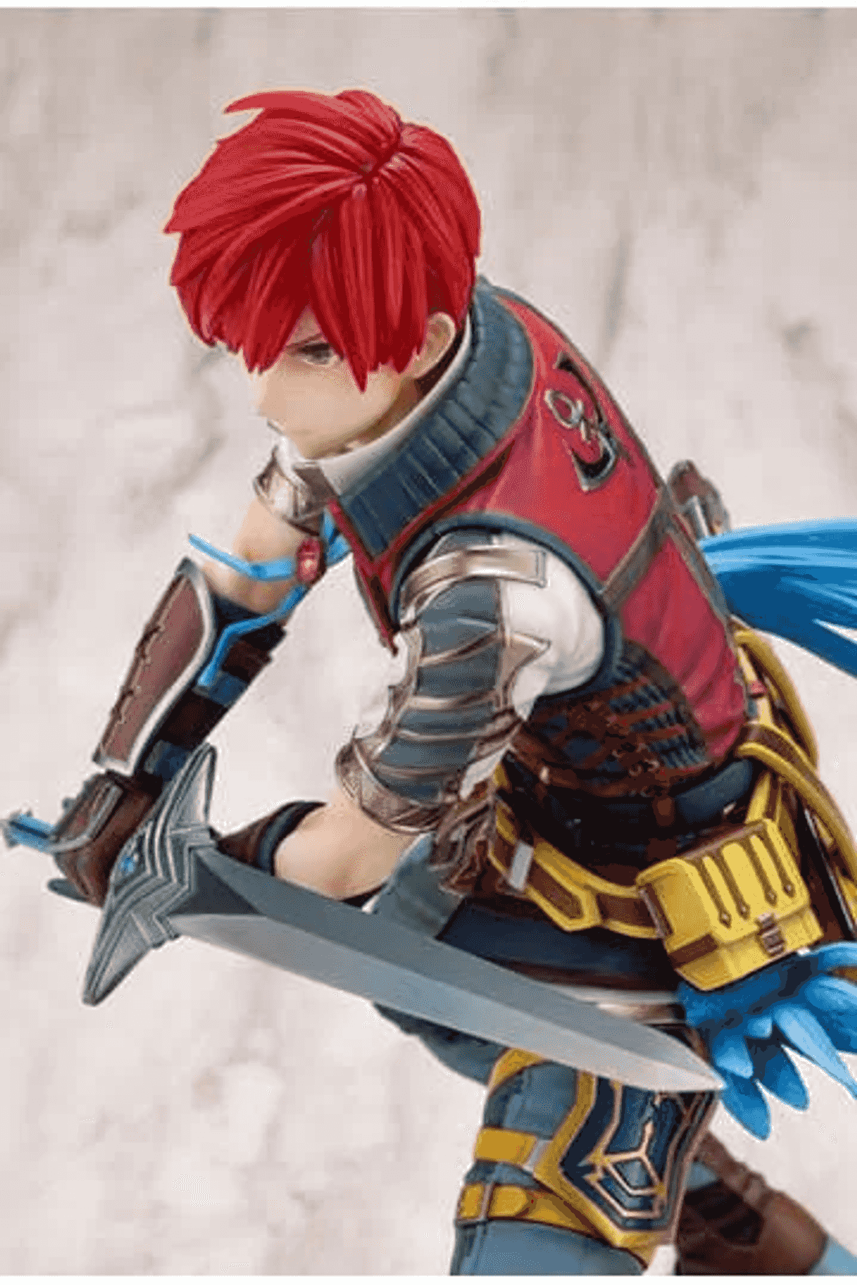 Una figura de acción con pelo rojo y espada, vistiendo armadura roja y azul.