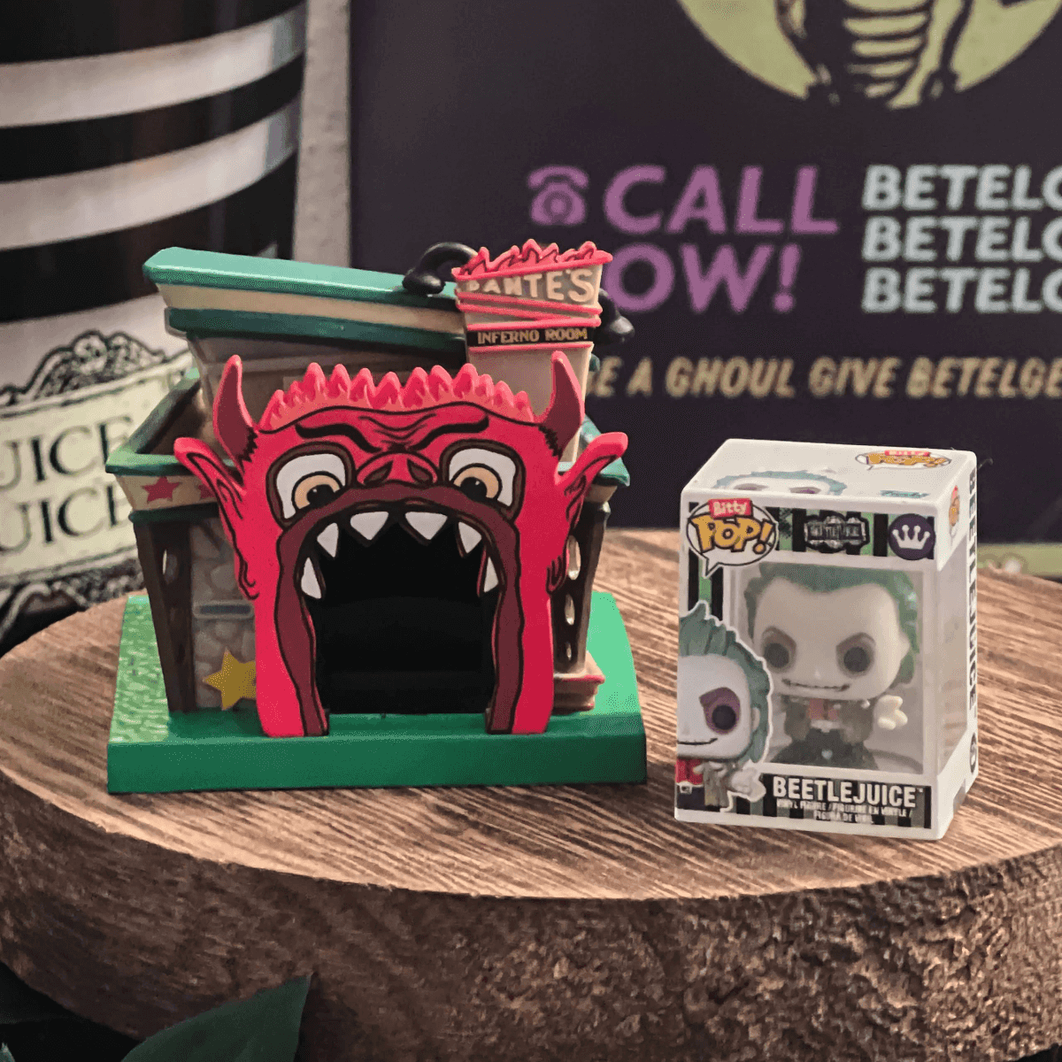 Un modelo de casa del diablo roja y una figura de Beetlejuice en un soporte de madera.