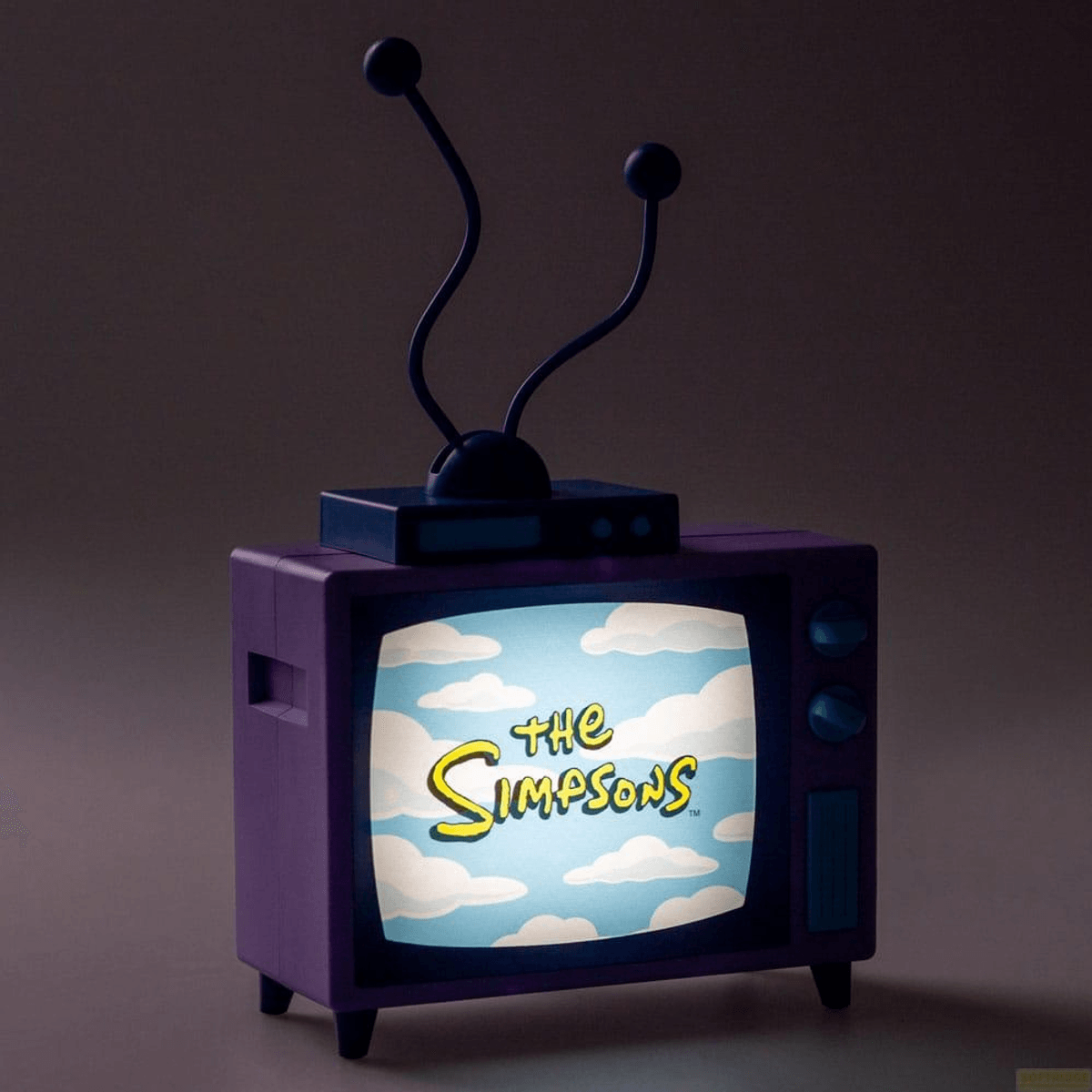Un televisor morado con antena muestra el logo de Los Simpson ante un cielo con nubes.
