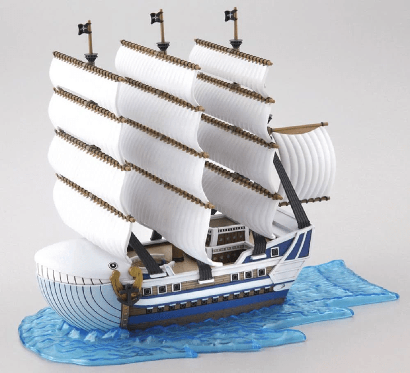 Un velero blanco con detalles azules sobre agua azul.