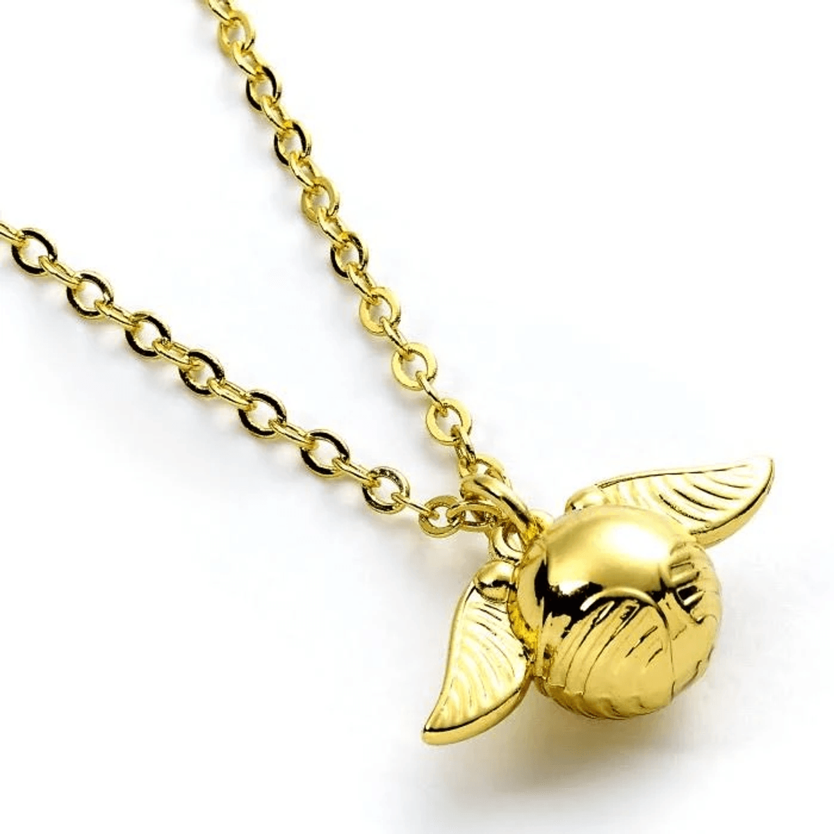 Primer plano de un collar de oro con un colgante de snitch dorada alada sobre fondo blanco.
