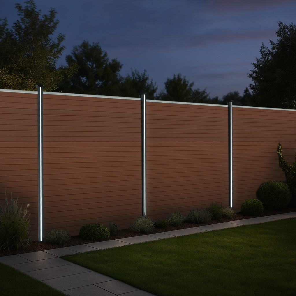 Una valla de madera marrón con tres luces verticales y un jardín delante.