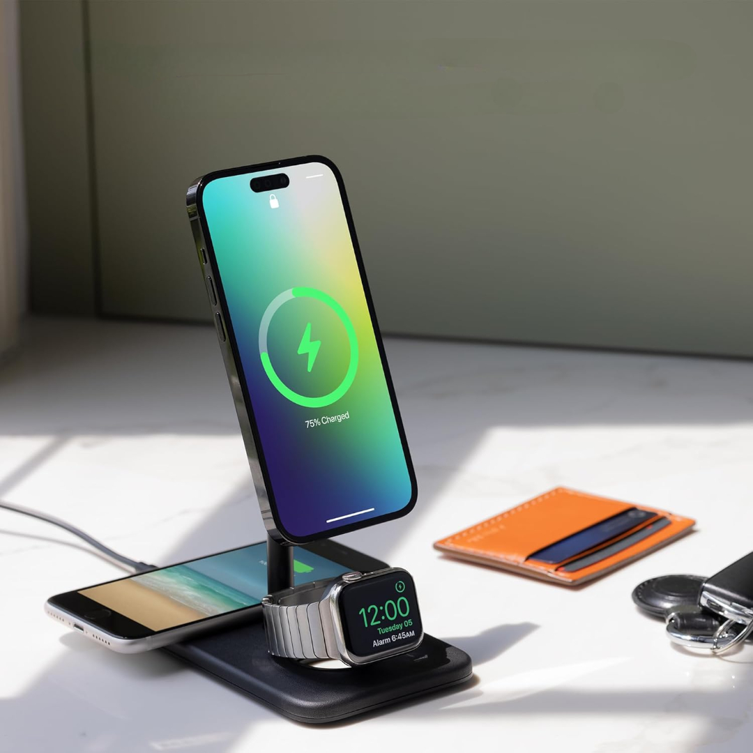 Telefon, zegarek i portfel na stojaku ładującym. Telefon naładowany w 75%.