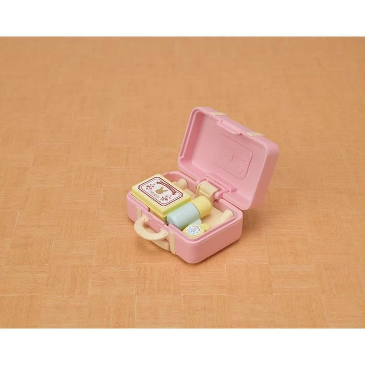 Ein rosa Spielzeugkoffer ist geöffnet und zeigt Miniatur-Toilettenartikel und eine Schachtel.