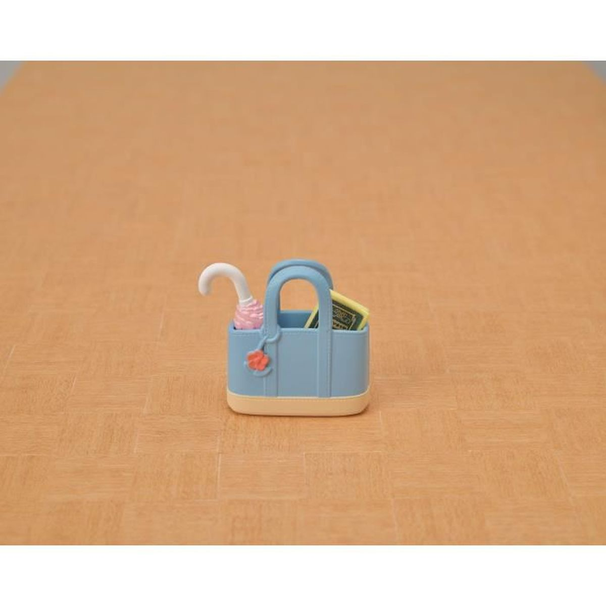 Eine blaue Tasche mit einem Miniaturregenschirm und etwas Geld.