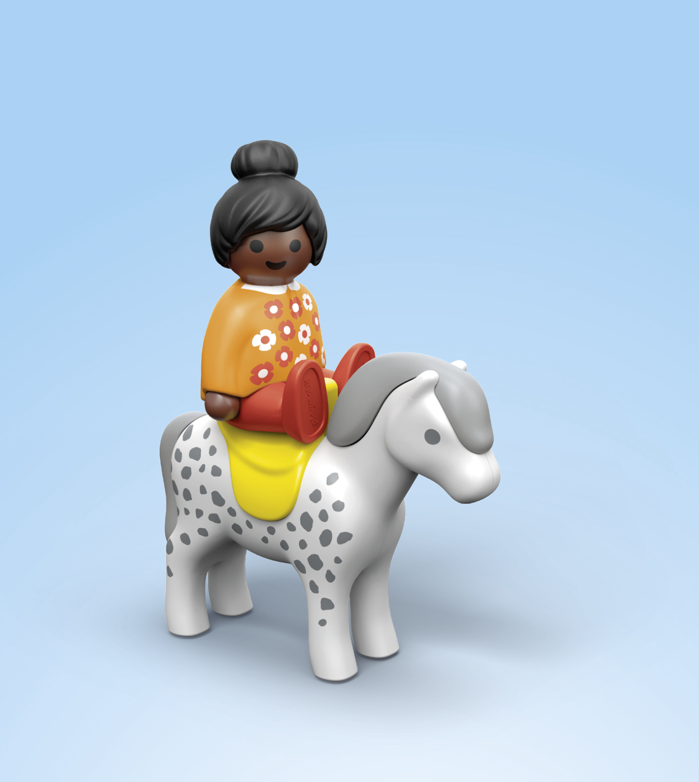 Una bambina dai capelli scuri siede su un cavallo maculato.