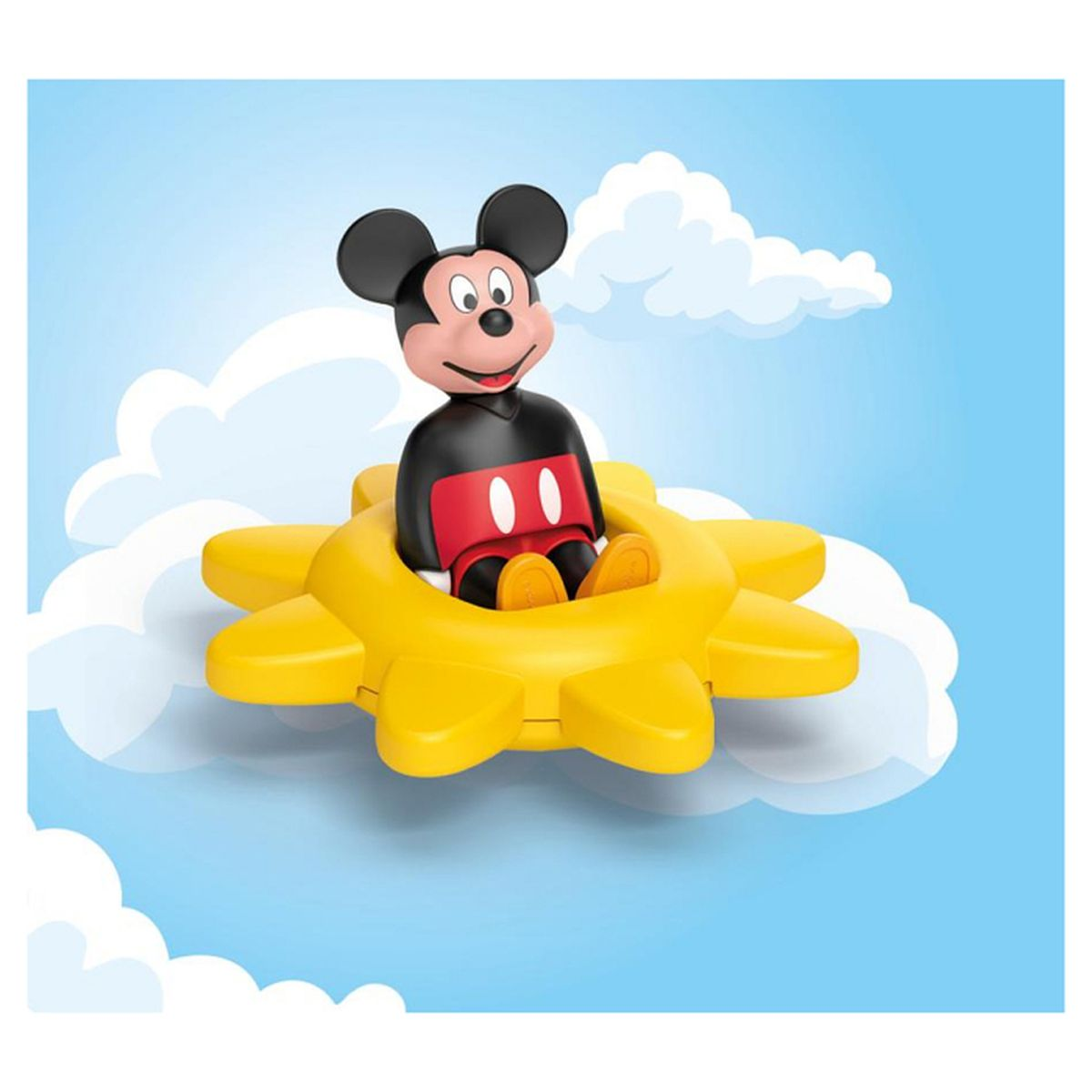 Micky Maus sitzt in einem gelben Sonnenrad vor blauem Himmel mit Wolken.