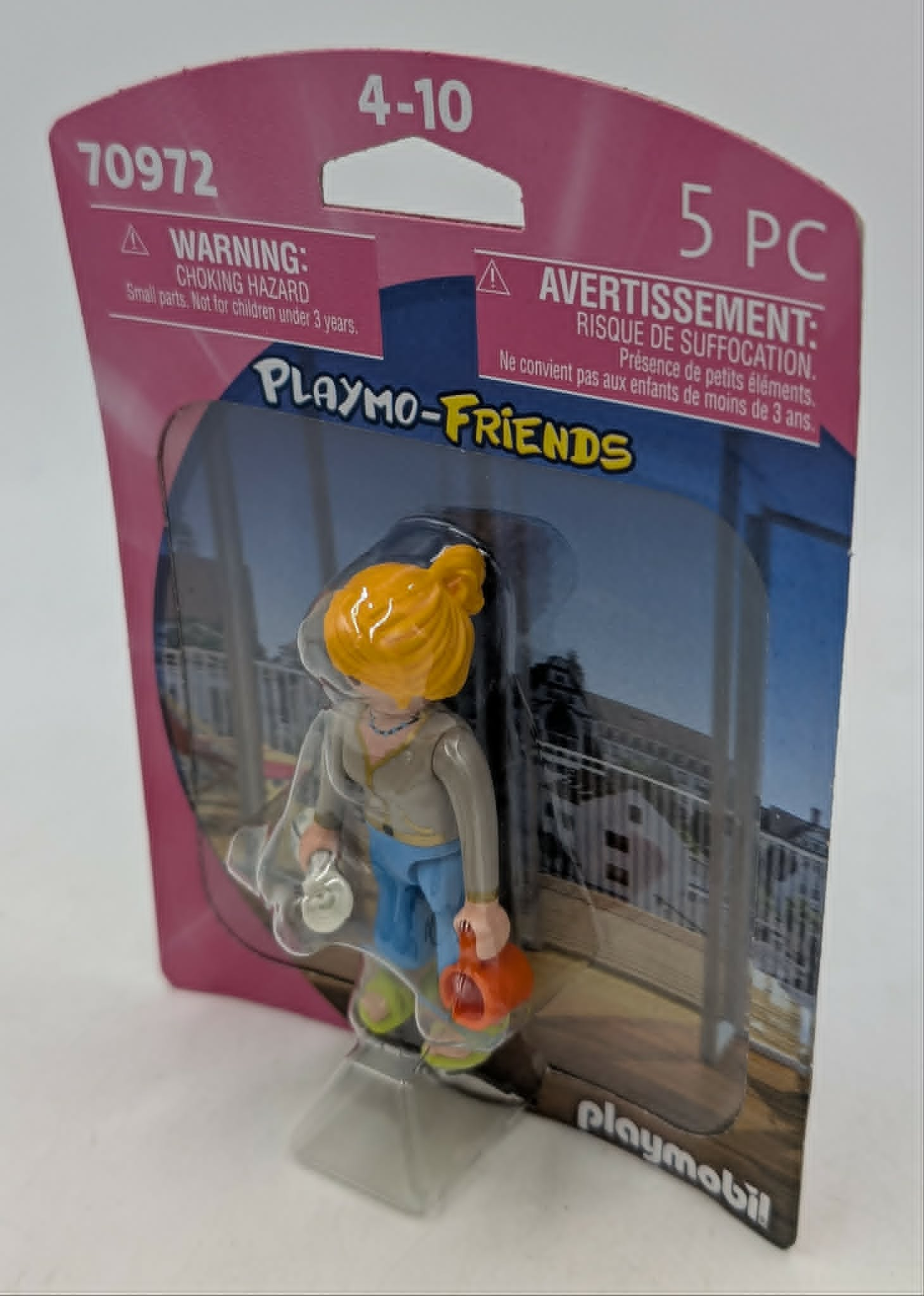 Figurka Playmobil Friends z blond włosami, niebieskimi spodniami, trzyma przedmioty.