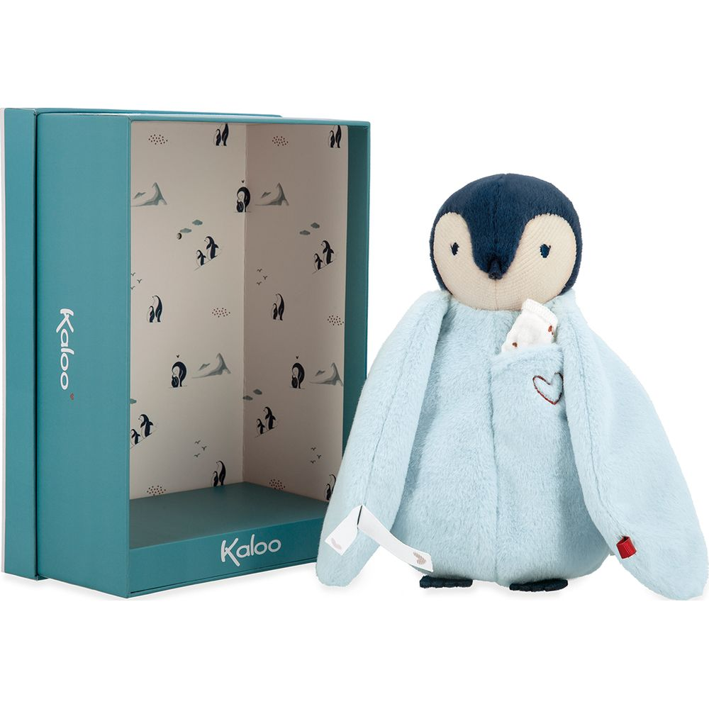 Un pinguino di peluche azzurro con testa scura e tasca siede accanto a una scatola aperta.