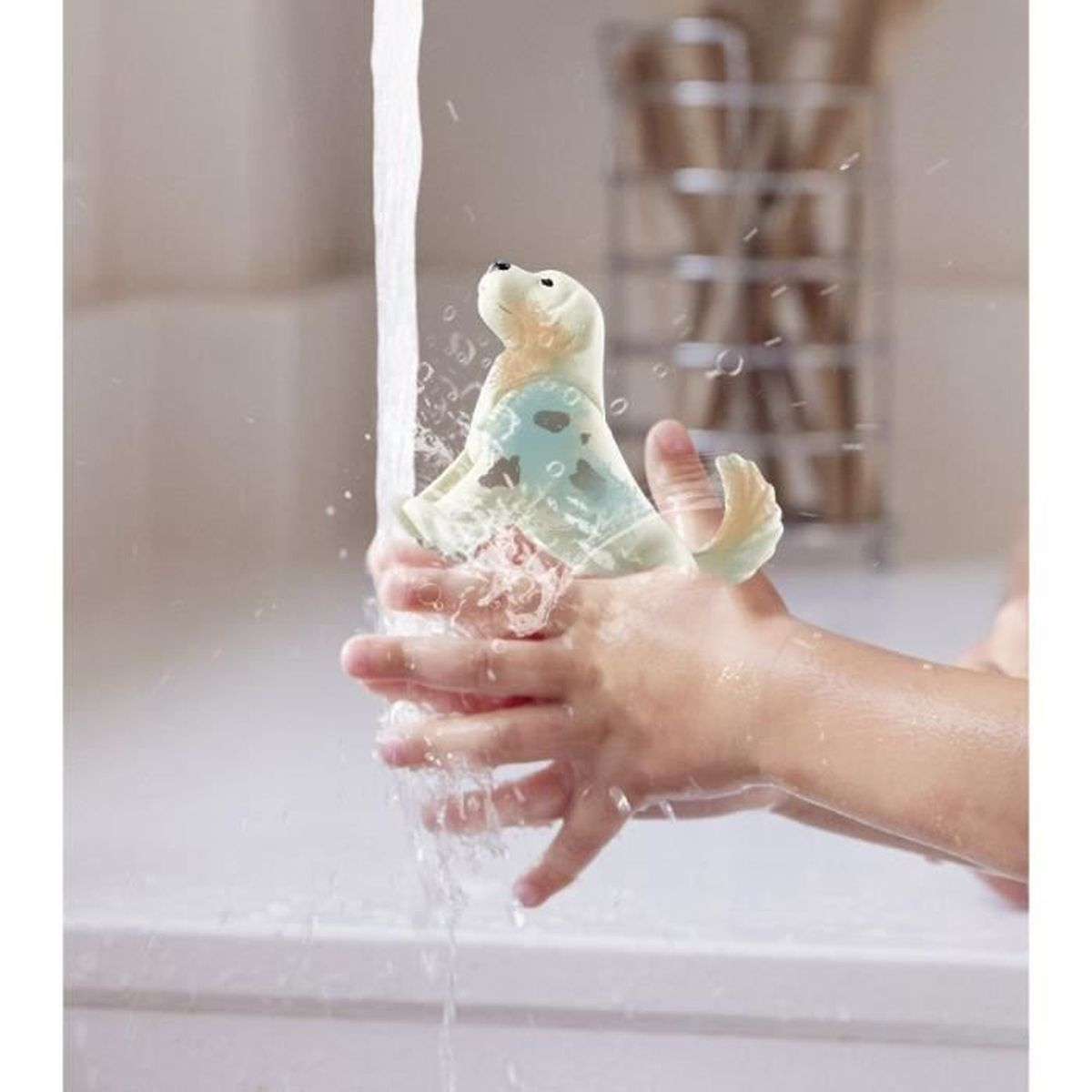 Ein Kind wäscht sich die Hände mit einem Robben-Spielzeug unter fließendem Wasser.