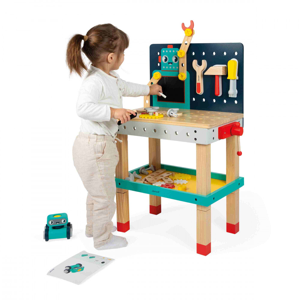 Une petite fille joue à un établi avec des outils et un design de robot.