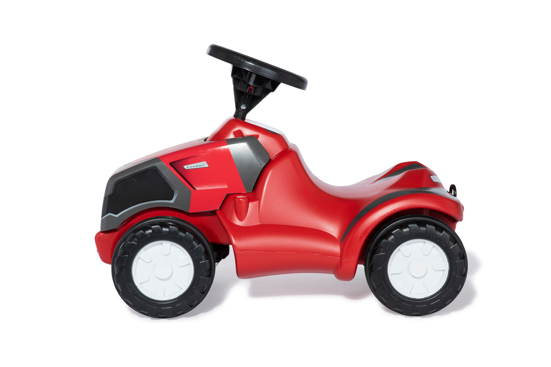 Un trattore giocattolo rosso con volante nero e cerchi bianchi.
