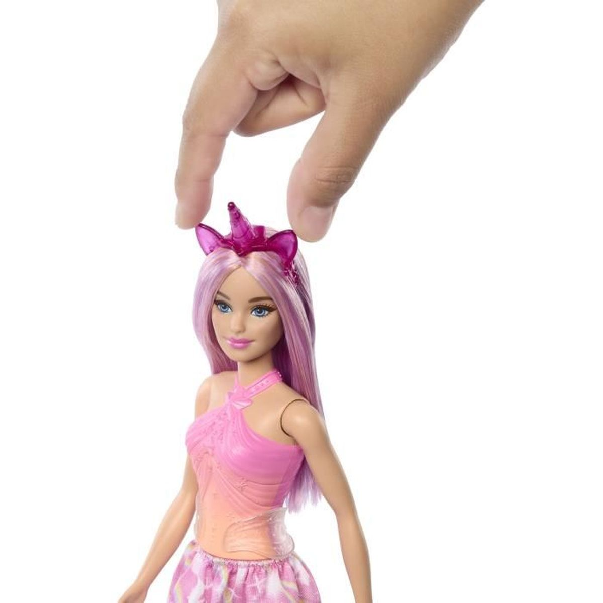 Eine Hand setzt ein pinkes Einhorn-Stirnband auf eine Barbie-Puppe mit lila Haaren.