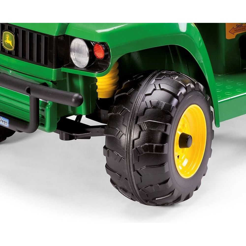 Gros plan d'une jeep jouet verte avec jante jaune et pneu noir.