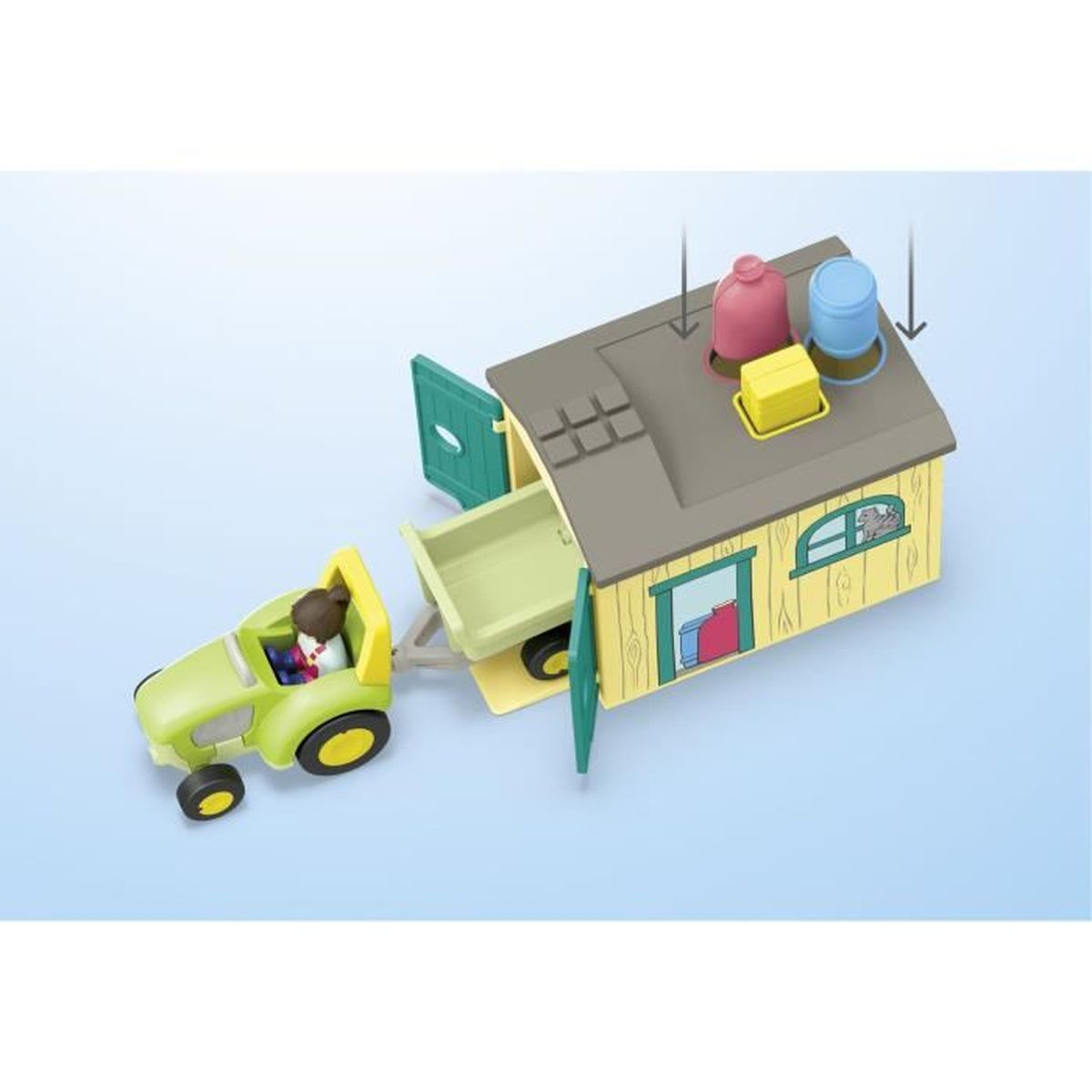 Un tractor de juguete con remolque y figura frente a una casa amarilla con puertas verdes.