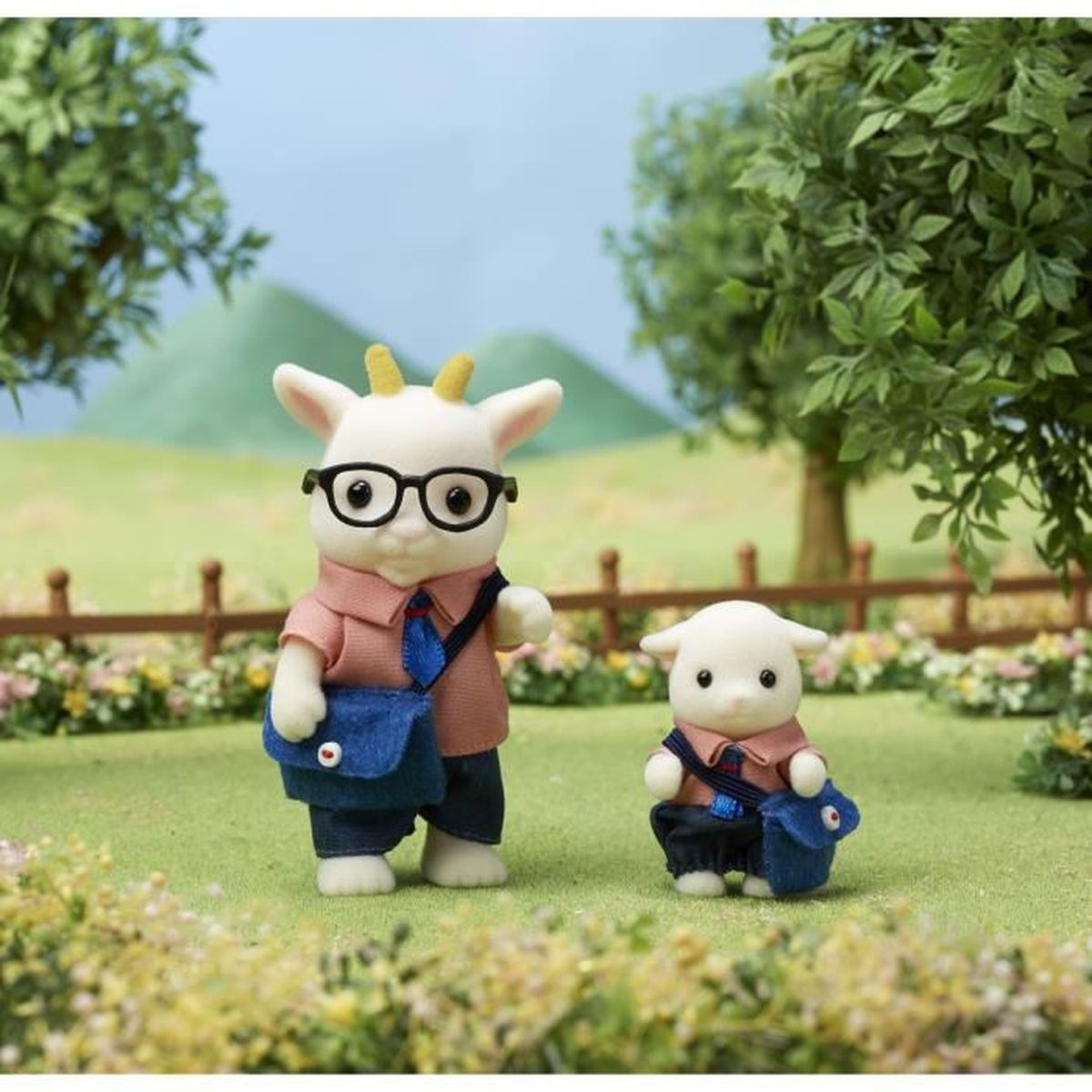 Dos figuras de cabra con gafas y bolsos están en hierba verde cerca de árboles.