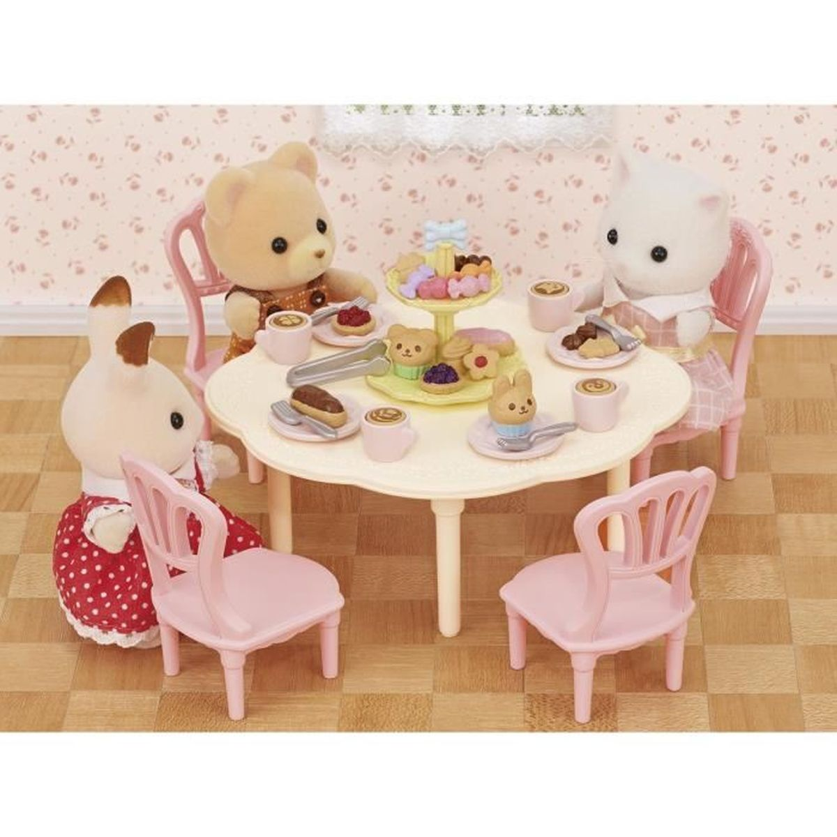Cuatro animales de juguete sentados en una mesa con té y pasteles. Un oso, un conejo, un gato.