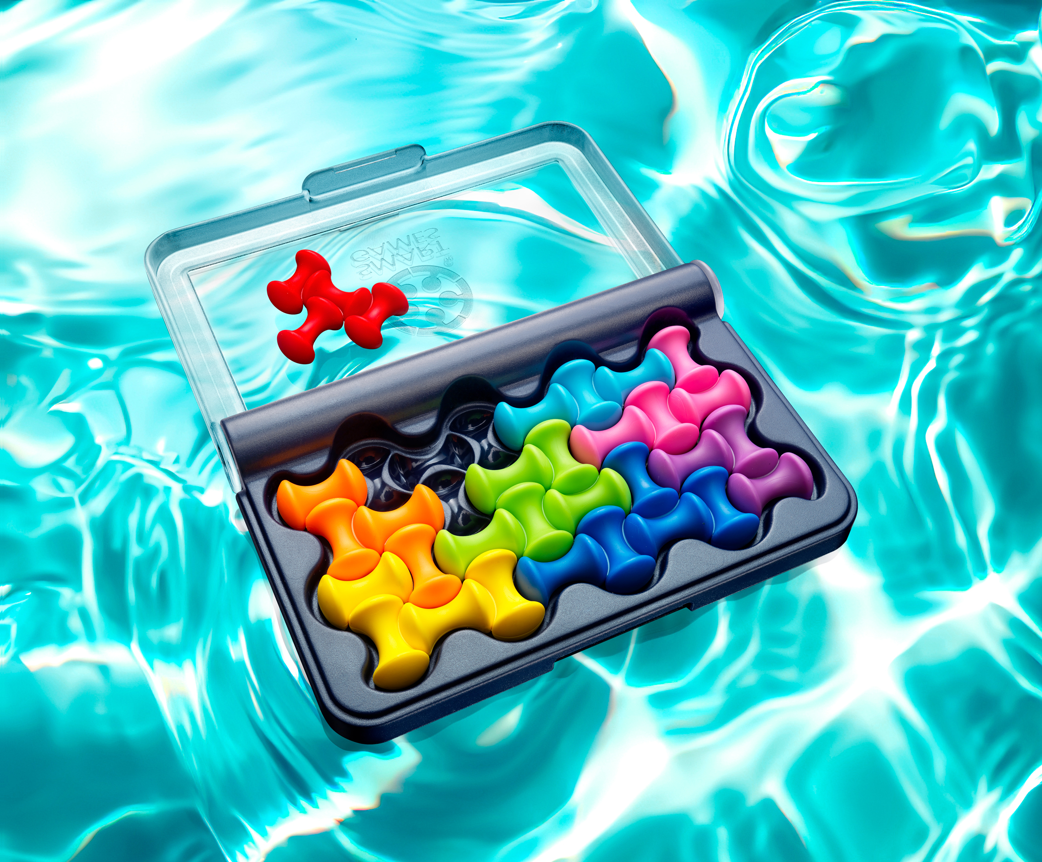 Un puzzle multicolore in una scatola nera su acqua blu.