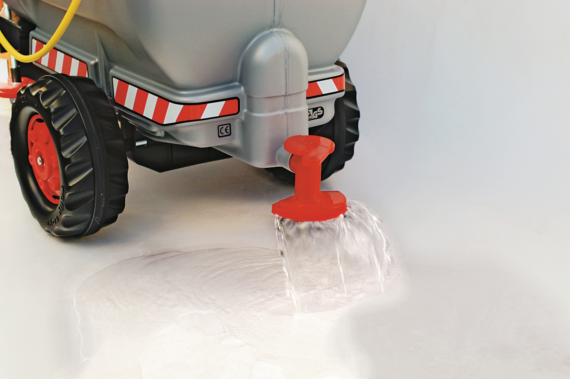 Carrello grigio con beccuccio rosso, acqua che scorre. Strisce riflettenti.