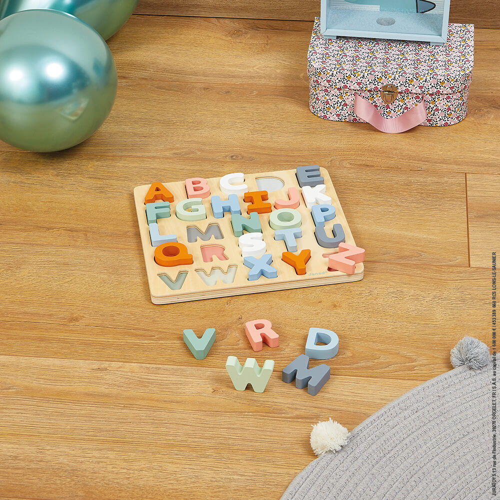 Holz-Alphabet-Puzzle mit bunten Buchstaben auf Holzboden, daneben Ballons.