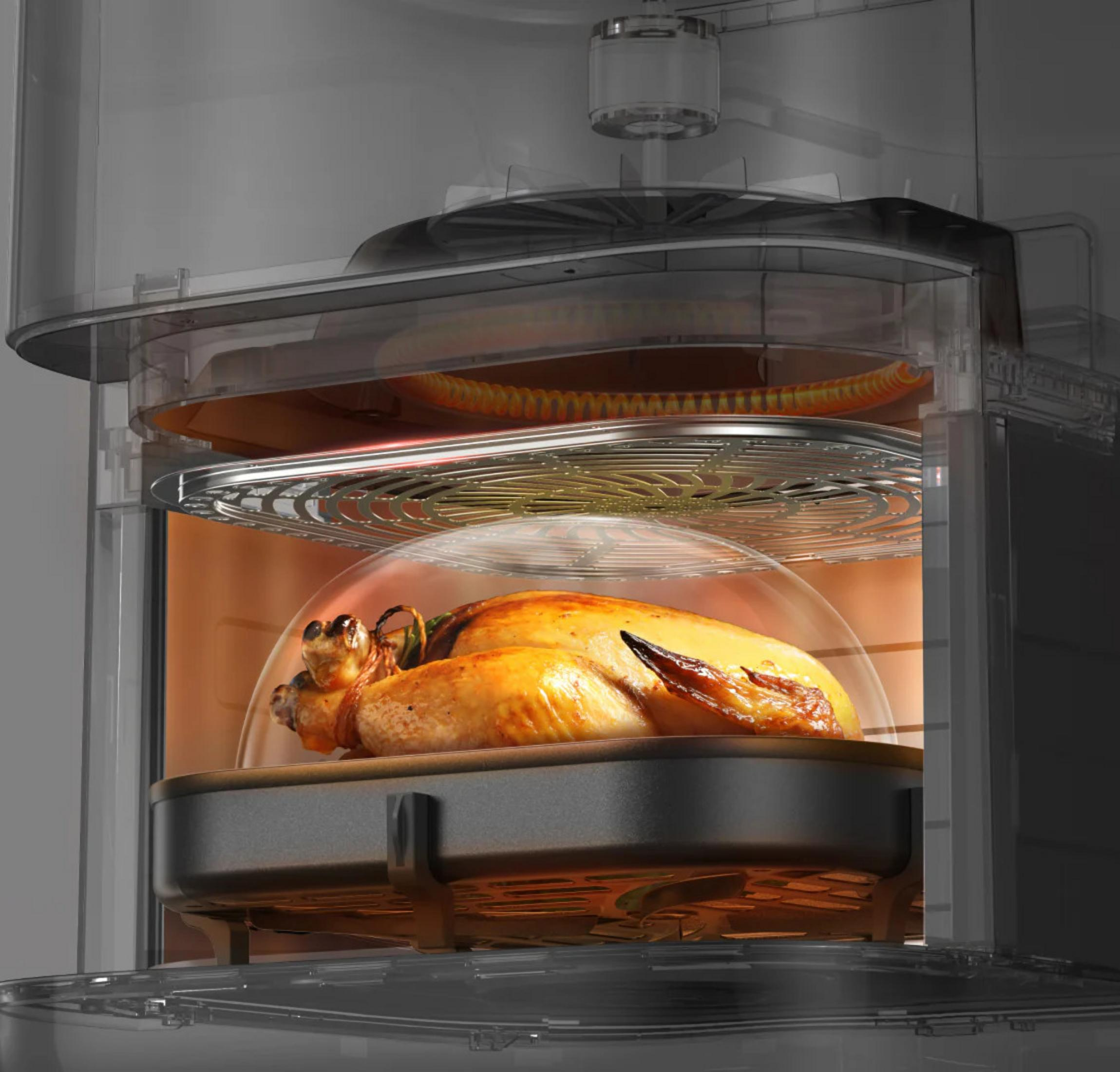 Un pollo arrosto dorato cuoce in un forno trasparente su una griglia.