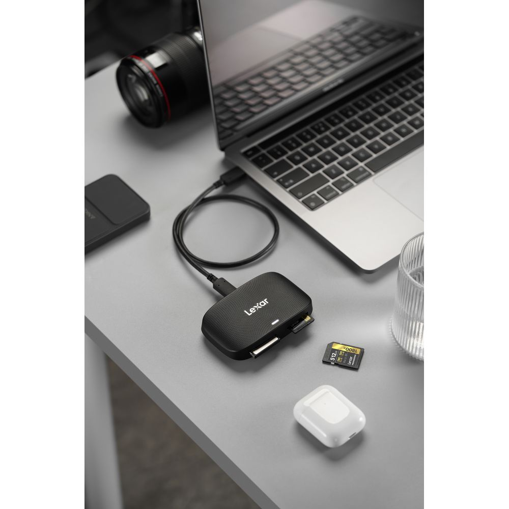 Lexar Kartenleser an Laptop angeschlossen, mit Kameralinse, SD-Karte, AirPods und Glas in der Nähe.