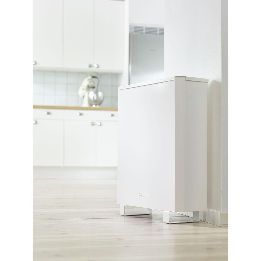 Un déshumidificateur blanc se trouve dans une cuisine moderne avec des armoires blanches et un comptoir en bois.