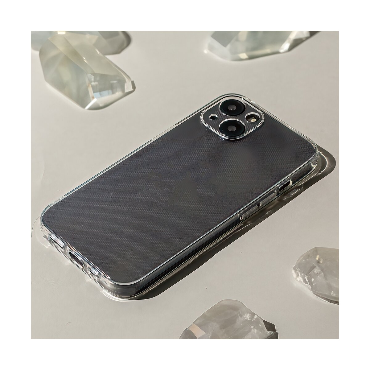 Ein transparentes Handy-Case liegt auf einer hellen Oberfläche neben kristallinen Objekten.