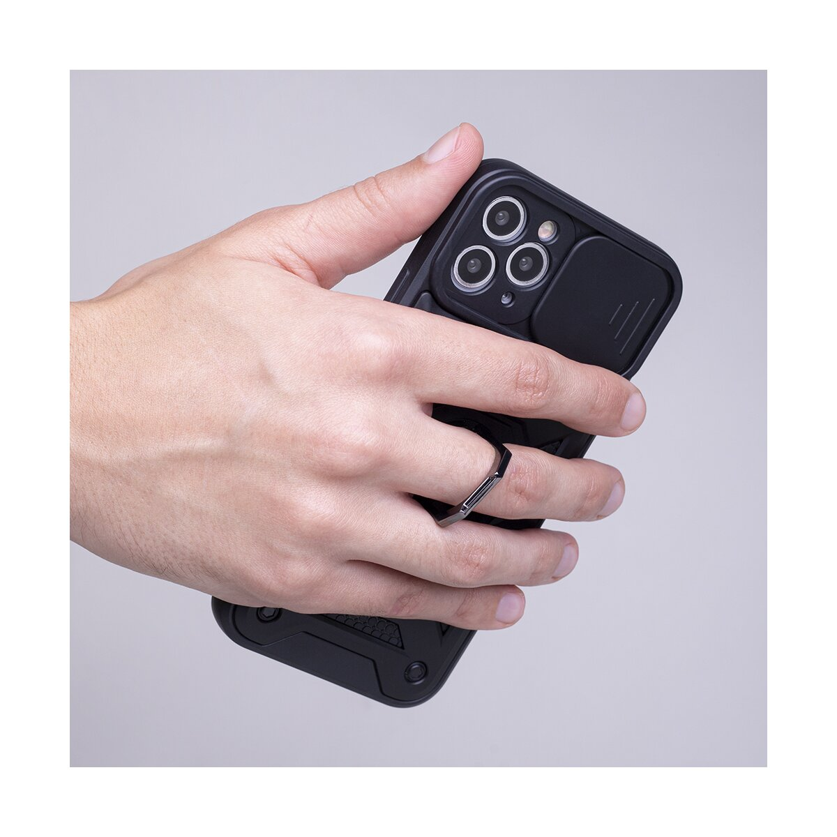 Hand hält schwarzes Handy mit Ringhalterung und Kamerabdeckung.