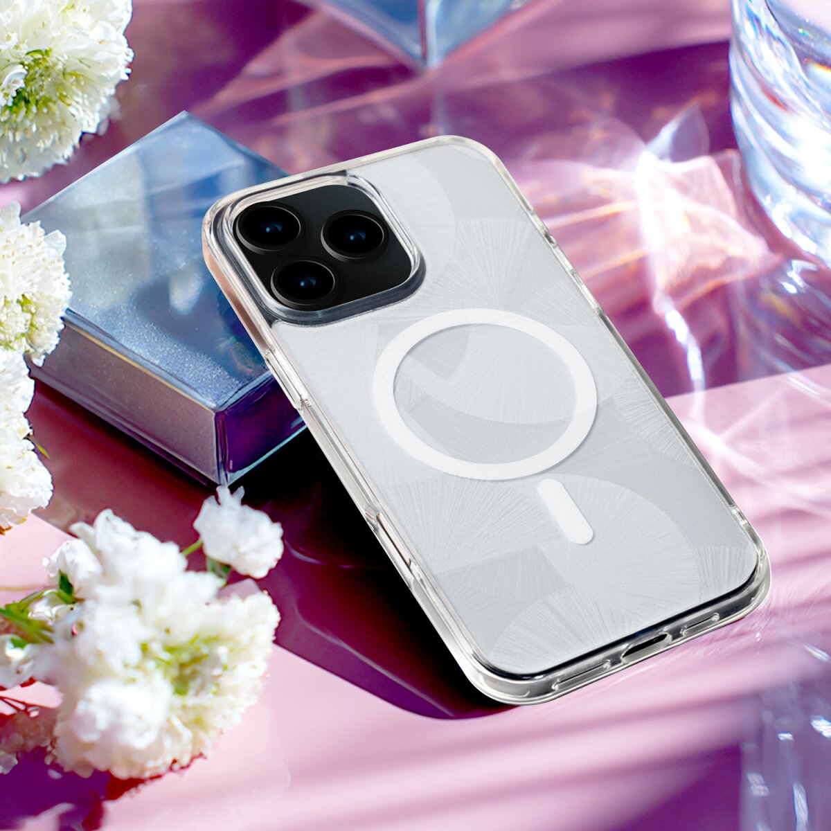 Ein durchsichtiges Handyhülle mit MagSafe-Ring auf einem rosafarbenen Hintergrund mit Blumen.