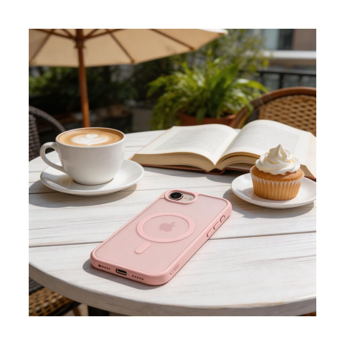 Ein rosafarbenes iPhone-Case liegt auf einem Tisch neben Kaffee und Cupcake.
