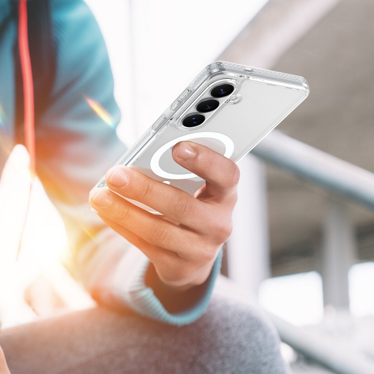 Eine Person hält ein Smartphone mit klarer Hülle und magnetischem Ring.